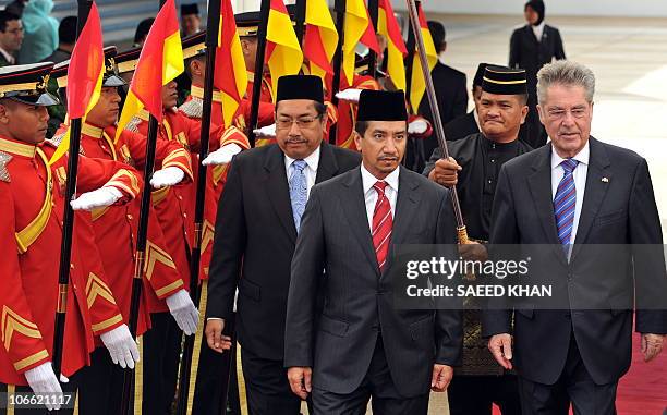 Malaysia's King Sultan Mizan Zainal Abidin and Austrian President Heinz Fischer walk towards the car after a guard of honour ceremony at the...