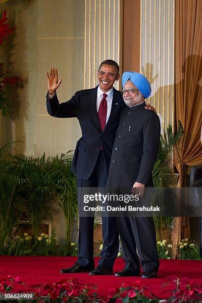 President Barack Obama waves as he stands with Indian Prime Minister Manmohan Singh after speaking during a joint press conference at Hyderabad House...