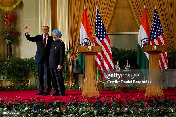 President Barack Obama waves as he stands with Indian Prime Minister Manmohan Singh after speaking during a joint press conference at Hyderabad House...