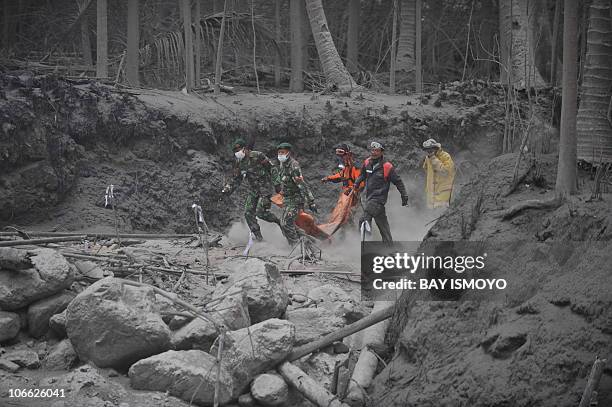 Rescue teams walk on the dry hot mud to evacuate victims from the eruption of Mount Merapi volcano at the village of Ampringan in Cangkringan-Sleman,...