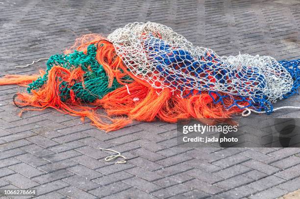 several coloured fishing nets - commercieel visnet stockfoto's en -beelden