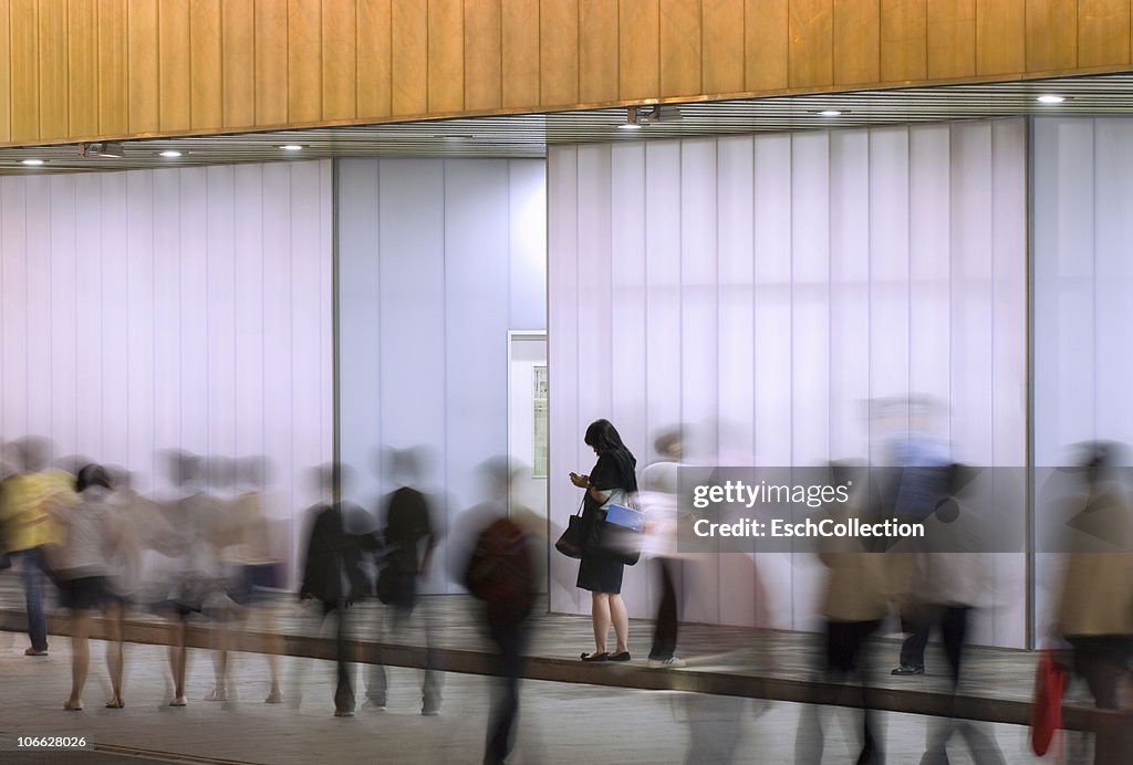 People passing modern illuminated building