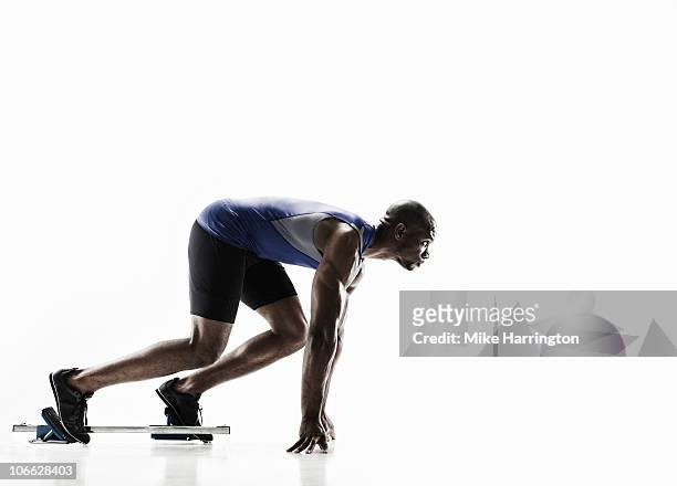 athletic black male in starting blocks - sprint photos et images de collection