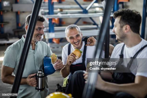 gelukkig arbeiders en hun manager praten op een lunch break in een fabriek. - lunchpauze stockfoto's en -beelden