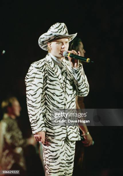 Irish singer and songwriter Ronan Keating of Boyzone performs at Wembley Arena in a faux zebra-skin ensemble, circa 1997.