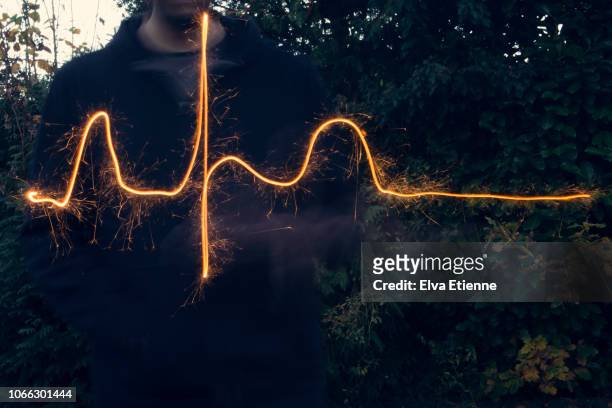 long exposure of sparkler used to draw out a normal heart rhythm - pulse trace stockfoto's en -beelden
