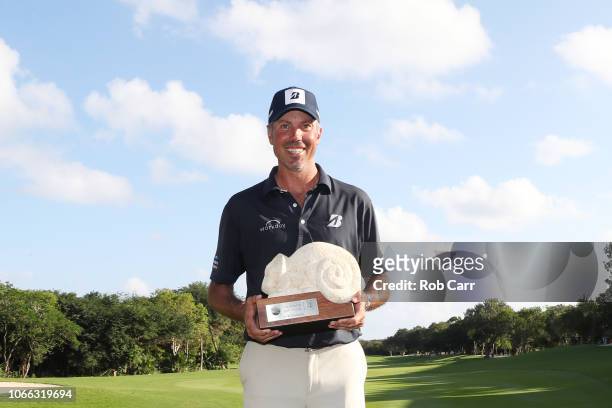 Matt Kuchar of the United States celebrates with the winner's trophy on the 18th green after the final round of the Mayakoba Golf Classic at El...
