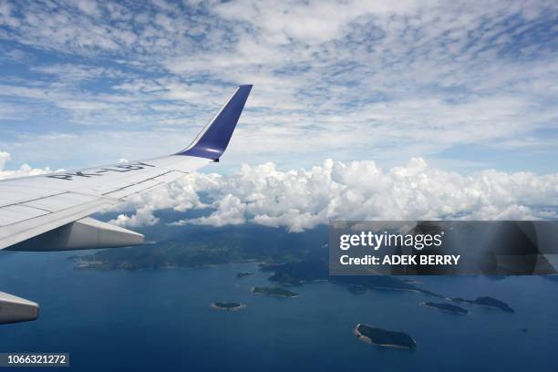 This picture taken on November 27, 2018 shows the wing of a Batik airline plane during a flight in Indonesia. Indonesia is one of the world's...