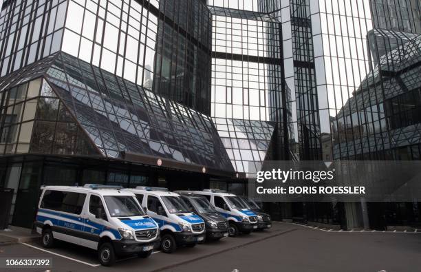 Police vehicles are parked at Deutsche Bank's headquarters in Frankfurt on November 29, 2018. - German prosecutors raided several Deutsche Bank...