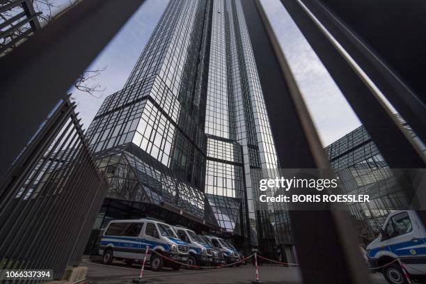 Police vehicles are parked at Deutsche Bank's headquarters in Frankfurt on November 29, 2018. - German prosecutors raided several Deutsche Bank...