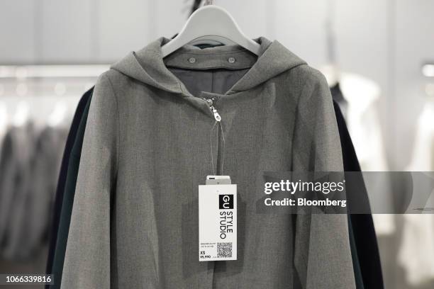 Price tag with a quick respond code for online shopping hangs from a jacket at the GU Style Studio store, operated by Fast Retailing Co., in Tokyo,...