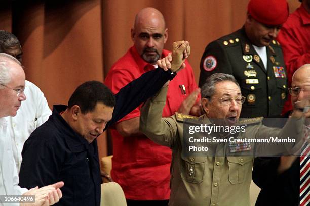Cuban President Raul Castro raises the arm of Venezuela President Hugo Chavez at the end of a meeting to celebrate the 10th anniversary of the...