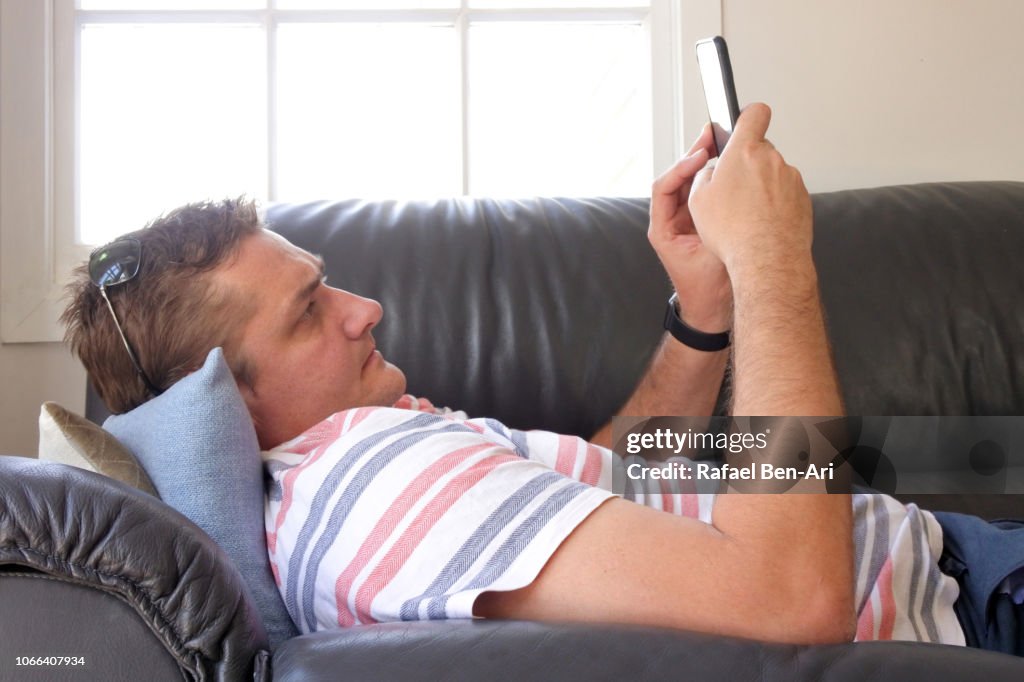 Adult Man Using his Mobile Phone at Home