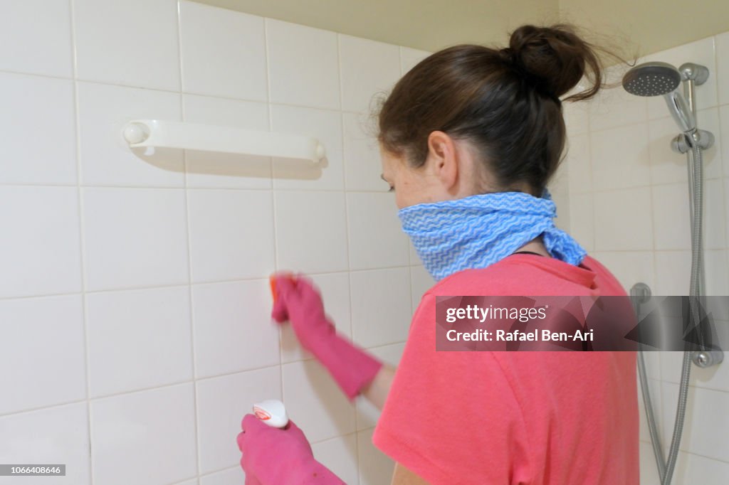 Woman Cleaning Shower with Cleaning Gloves