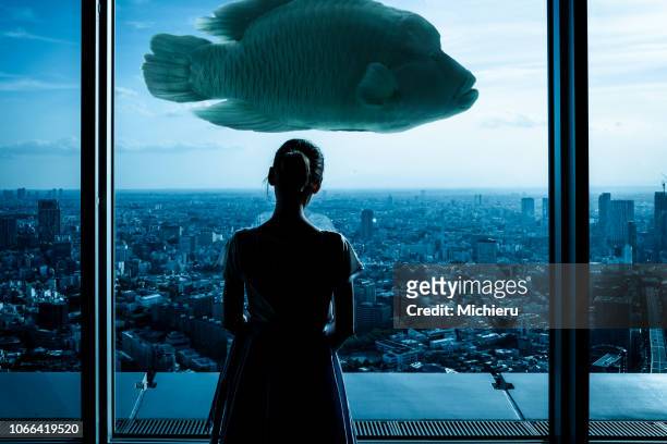 art photo - a girl, fish, city - surreal stock-fotos und bilder
