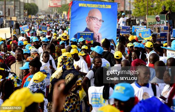 Senegal's opposition demonstrators hold pictures of former minister Karim Wade and of the Mayor of Dakar Khalifa Sall during a march to demand...