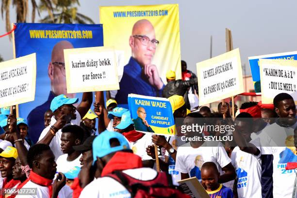 Senegal's opposition demonstrators hold pictures of former minister Karim Wade during a march to demand transparency in next year's elections, in...