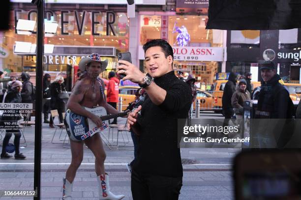 Mario Lopez records a selfie with iconic New York figure 'The Naked Cowboy' while hosting 'Extra' on November 29, 2018 in New York City.