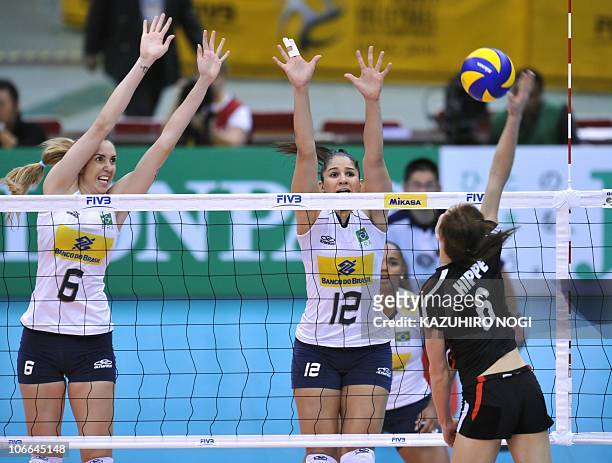 Brazil's Thaisa Menezes and Natalia Pereira jump to block a spike by Germany's Saskia Hippe during their second round match of the world women's...