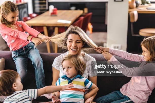 playful kids having fun with their nanny at home. - hair pulling stock pictures, royalty-free photos & images