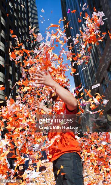 man throwing confetti during a celebration - paraden stock-fotos und bilder