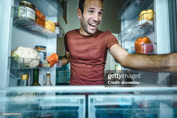 человек рассматривает содержимое холодильника