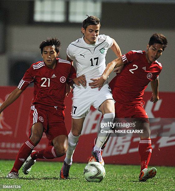 Uzbekistan's Ivan Nagaev is sandwiched between Hong Kong's Tsang Kam To and Lee Chi Ho in their 16th Asian Games men's group E pool football match in...