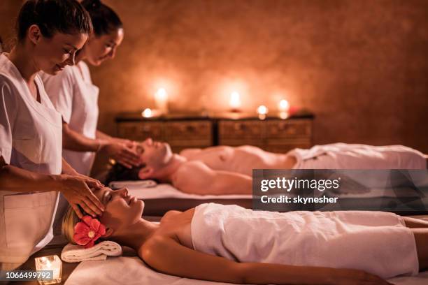 massaging young couple at the spa! - massage couple stock pictures, royalty-free photos & images