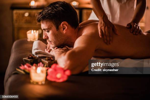 young man enjoying on a massage treatment at the spa. - aromatherapy stock pictures, royalty-free photos & images