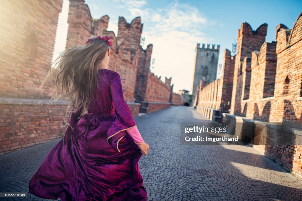 Julieta pequena correndo na ponte de Verona