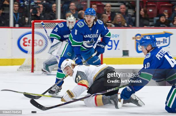 Christopher Tanev of the Vancouver Canucks looks on as teammate Elias Pettersson checks Cody Eakin of the Vegas Golden Knights during their NHL game...