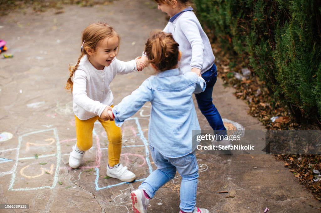 Amici più piccoli che giocano a hopscotch all'aperto