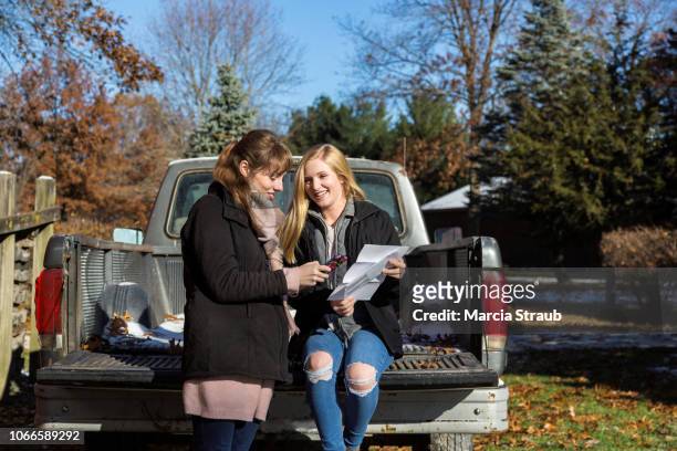 young woman doing on line banking on mobile phone - rural banking stock-fotos und bilder
