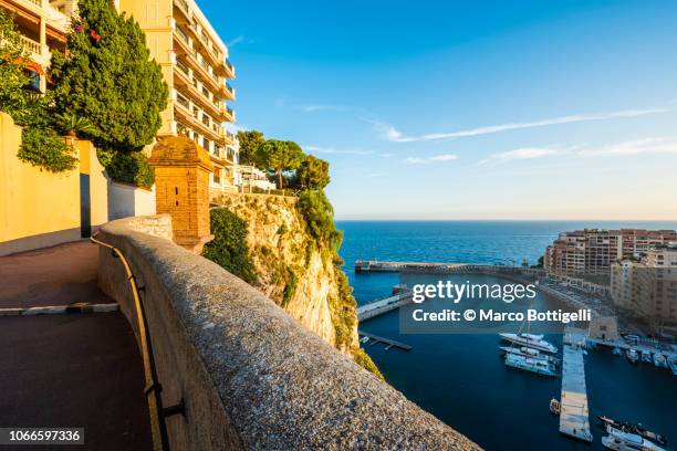 scenic walk on the rock of monaco overlooking port de fontvieille, monaco - monaco marina stock pictures, royalty-free photos & images