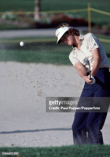 American professional golfer Beth Daniel shoots out of a bunker, circa February 1983.