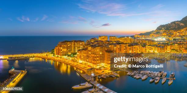 monaco view of port de fontvieille illuminated at dusk - monaco sunset stock pictures, royalty-free photos & images