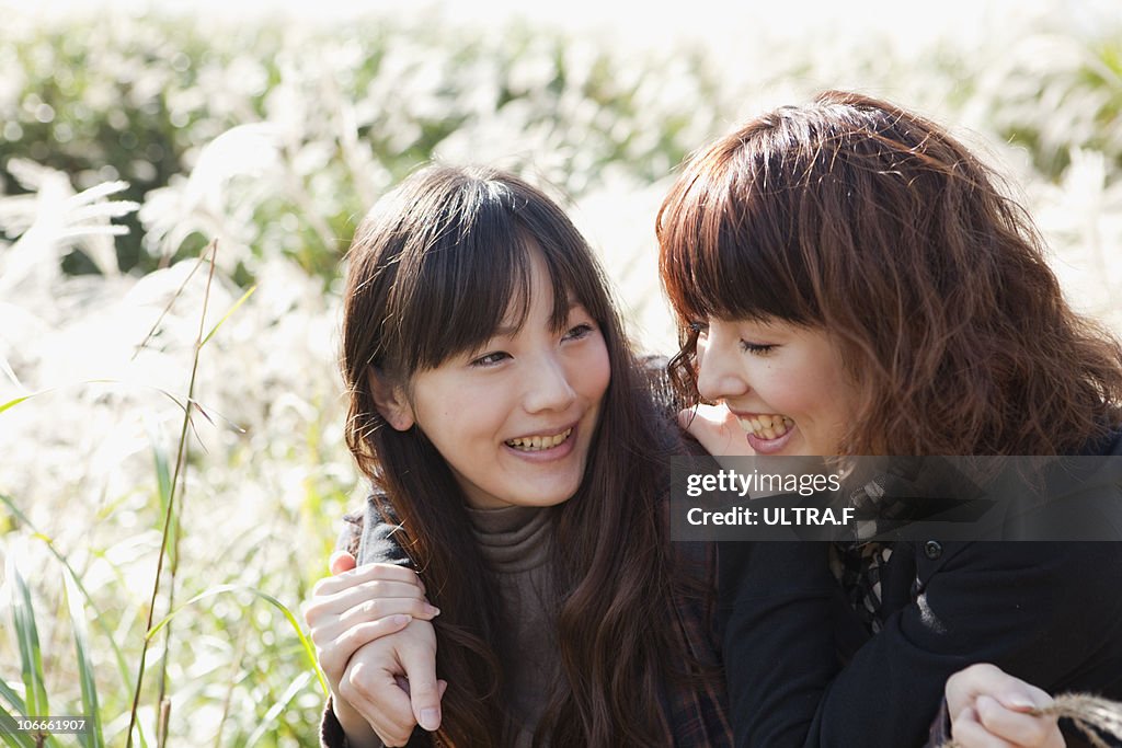 Young women plays in susuki grass meadow.