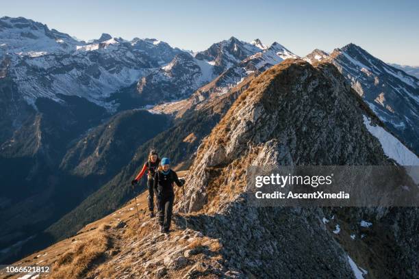 weibliche bergsteigern hochschieben bergrücken - bergsteiger gipfel stock-fotos und bilder