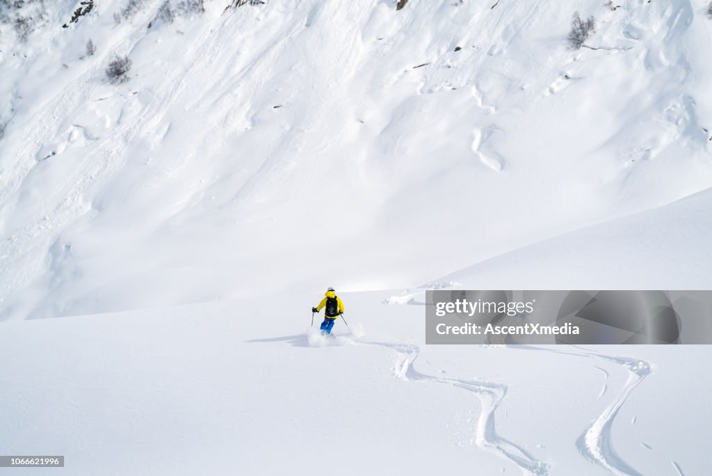 Backcountry skier flies down slope