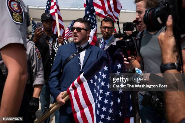 Jason Kessler, the organizer of the Unite the Right rally, is interviewed by reporters while police escort him into the Vienna metro station before...