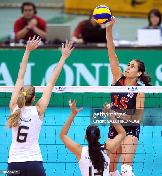 Attacker Logan Tom spikes the ball over Brazilian players Thaisa Menezes and Sheilla Castro during their second round match of the world women's...