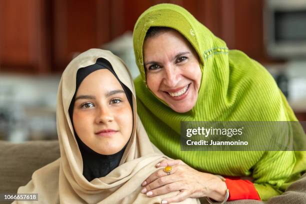muslim mature woman posing with her young daughter - egyptian family stock pictures, royalty-free photos & images