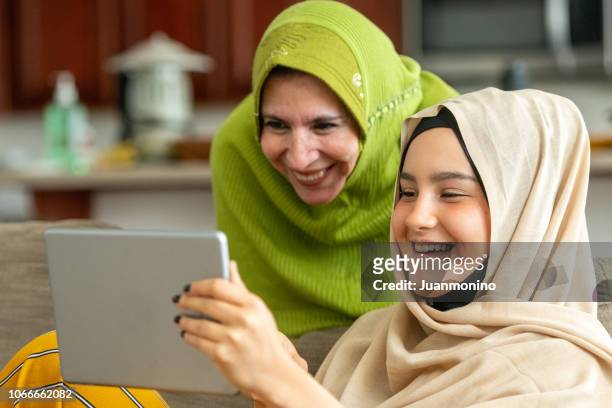muslim mature woman posing with her young daughter - egyptian family stock pictures, royalty-free photos & images
