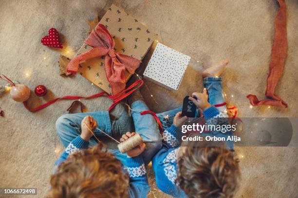 kids wrapping christmas gifts - child christmas present stock pictures, royalty-free photos & images