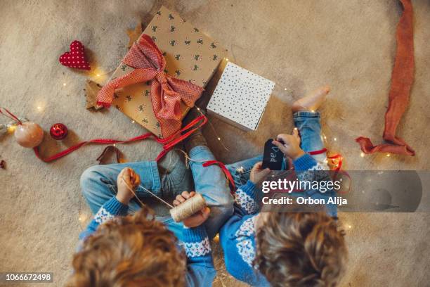 kids wrapping christmas gifts - bois noel stock pictures, royalty-free photos & images