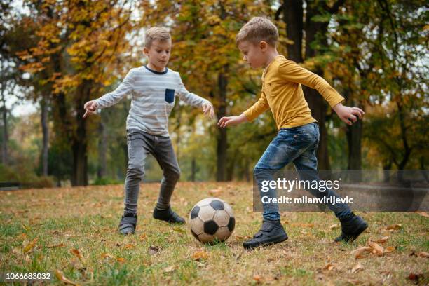 father playing football with children in park - american football player stock pictures, royalty-free photos & images
