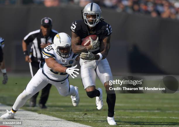 Martavis Bryant of the Oakland Raiders running with the ball fights off the tackle of Hayes Pullard of the Los Angeles Chargers during the first half...