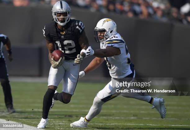 Martavis Bryant of the Oakland Raiders running with the ball fights off the tackle of Hayes Pullard of the Los Angeles Chargers during the first half...