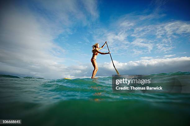 female stand up paddle boarder paddling on ocean - paddleboard stock pictures, royalty-free photos & images