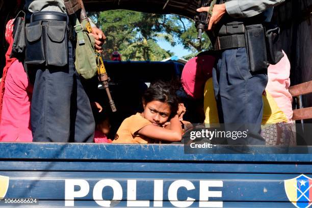 Myanmar police escort Rohingya Muslims back to their camp in Sittwe, Rakhine state, on November 30, 2018. - Nearly 100 Rohingya Muslims were forced...